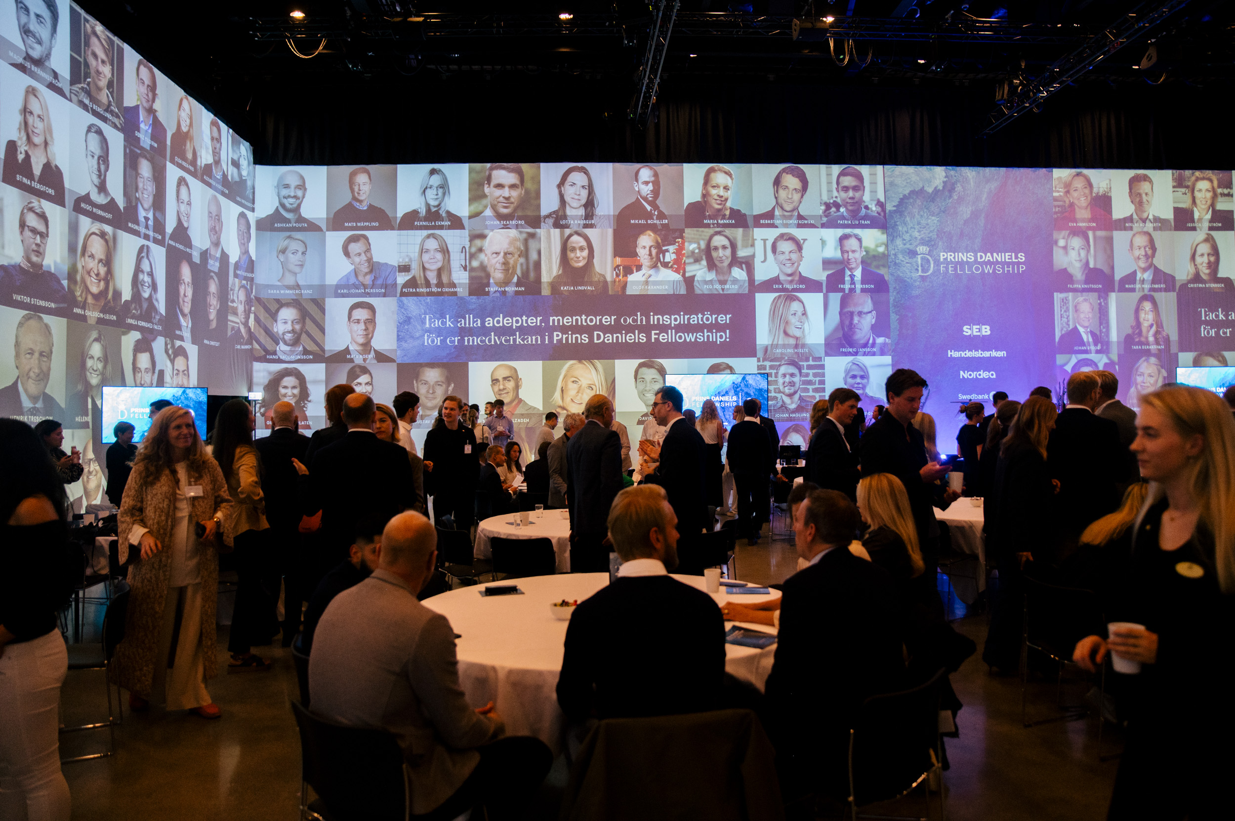 människor runt bord med foton på entreprenörer som bakgrund